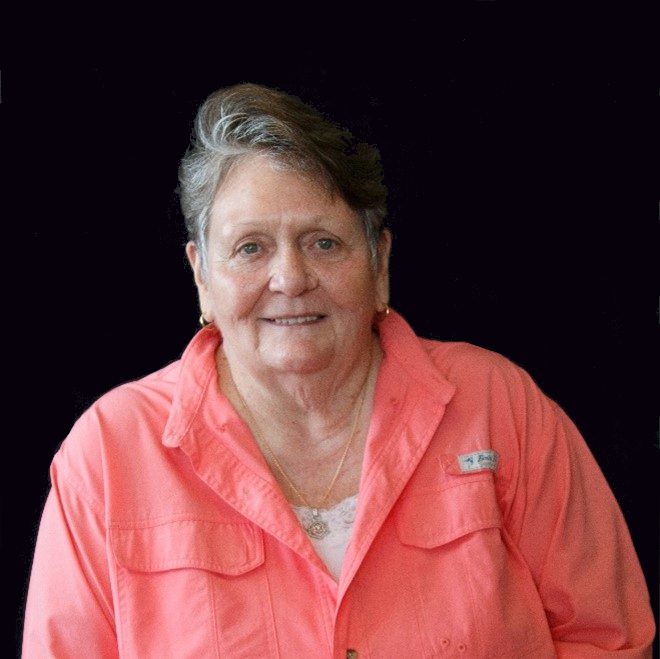 A woman in pink shirt smiling for the camera.