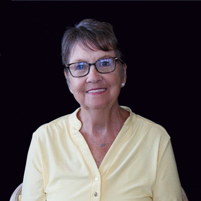 A woman in glasses and a yellow shirt