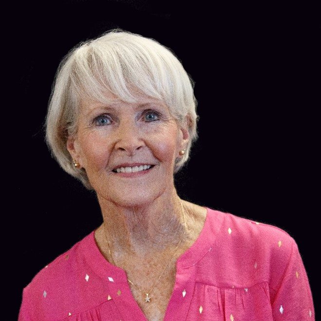 A woman with white hair wearing pink shirt.