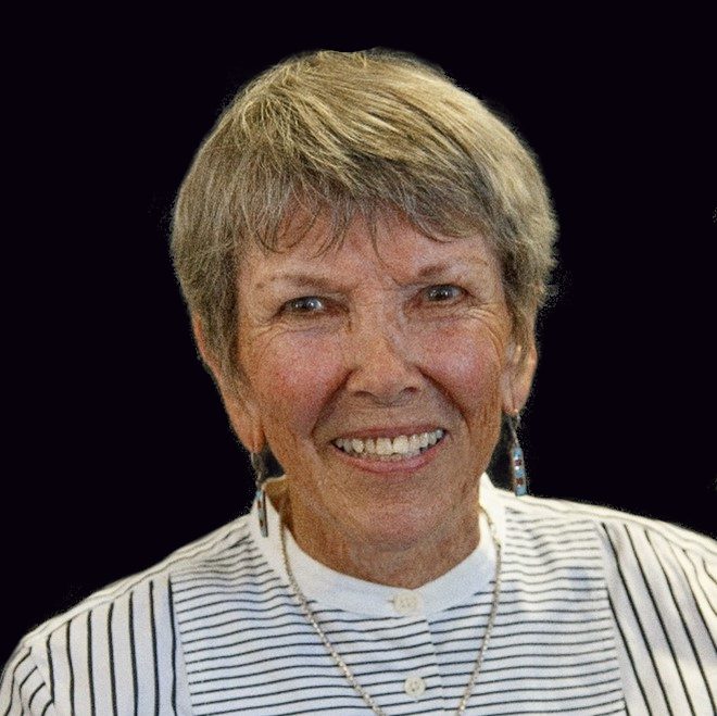 A woman with short hair and wearing a striped shirt.